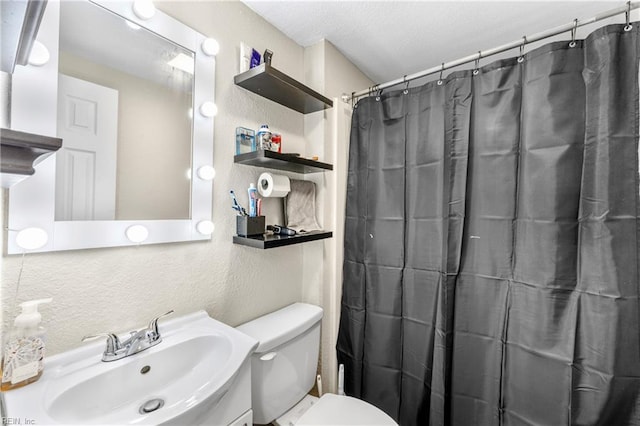 full bath with toilet, a textured wall, curtained shower, and vanity
