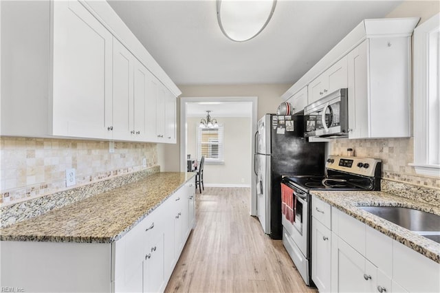 kitchen with tasteful backsplash, stainless steel appliances, light wood finished floors, and white cabinetry