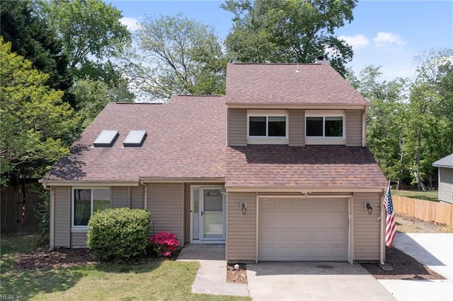 view of front of property with driveway, a front yard, roof with shingles, fence, and an attached garage