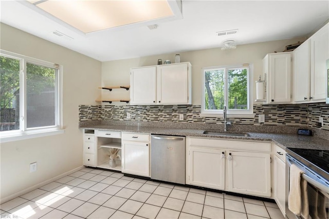 kitchen featuring visible vents, open shelves, tasteful backsplash, a sink, and stainless steel appliances