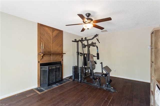 workout area with baseboards, a ceiling fan, and hardwood / wood-style floors