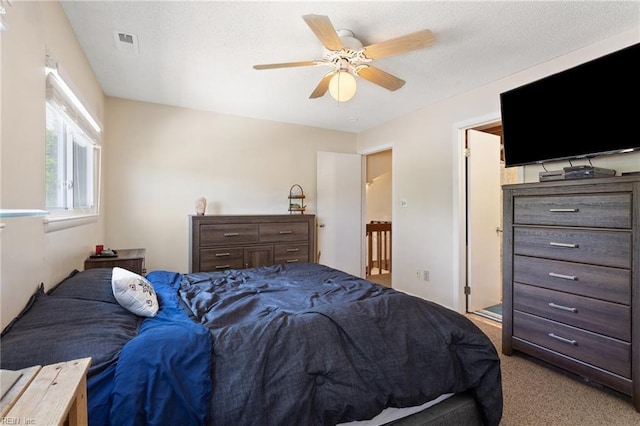 bedroom with visible vents, carpet flooring, and a ceiling fan