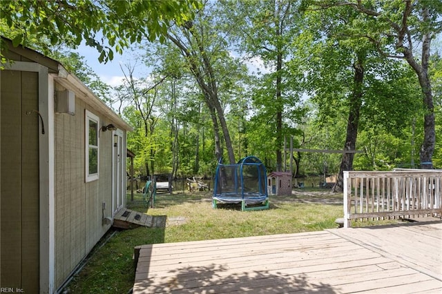 wooden terrace featuring a trampoline and a yard