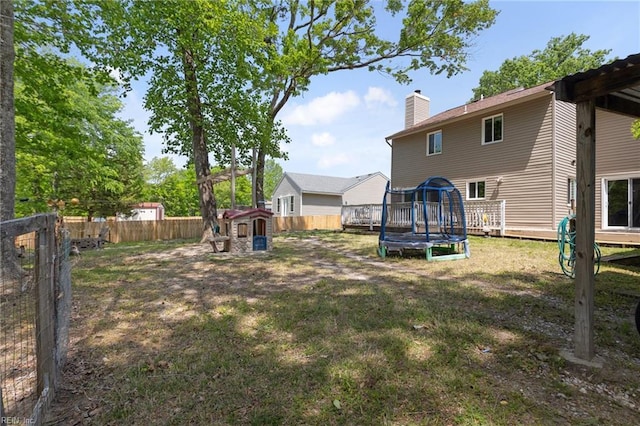 view of yard featuring a fenced backyard, a storage unit, a trampoline, and an outdoor structure