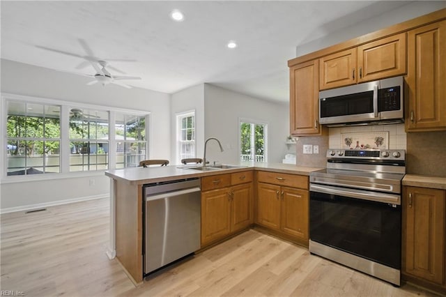 408 Leffler Ln, Virginia Beach, VA 23452 - kitchen featuring a sink, light wood-style floors, a ceiling fan, a peninsula, and appliances with stainless steel finishes