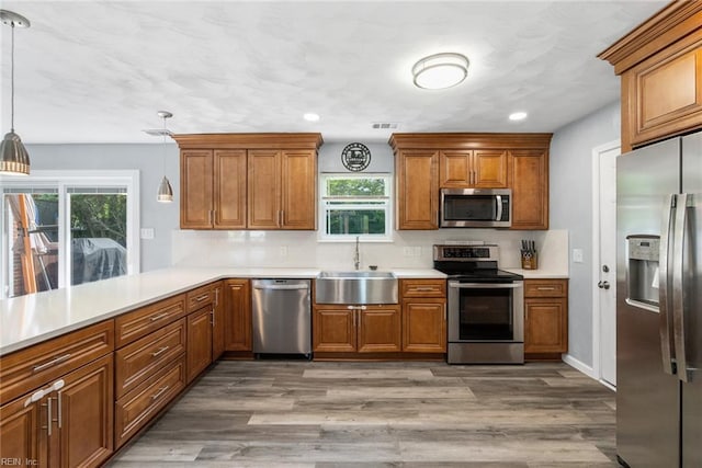 kitchen with a sink, appliances with stainless steel finishes, and brown cabinetry