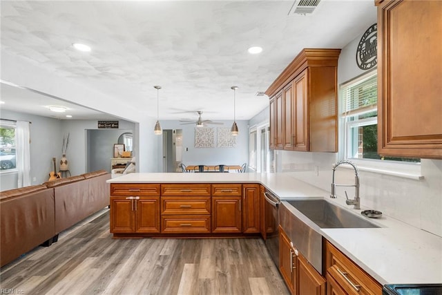 kitchen featuring open floor plan, visible vents, brown cabinetry, and a sink