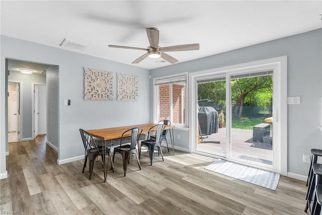 dining space featuring baseboards, a ceiling fan, light wood finished floors, and visible vents