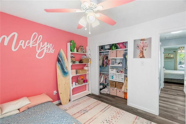 bedroom with a closet, a ceiling fan, baseboards, and wood finished floors
