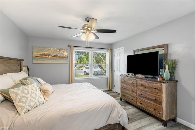 bedroom with baseboards, a ceiling fan, and wood finished floors