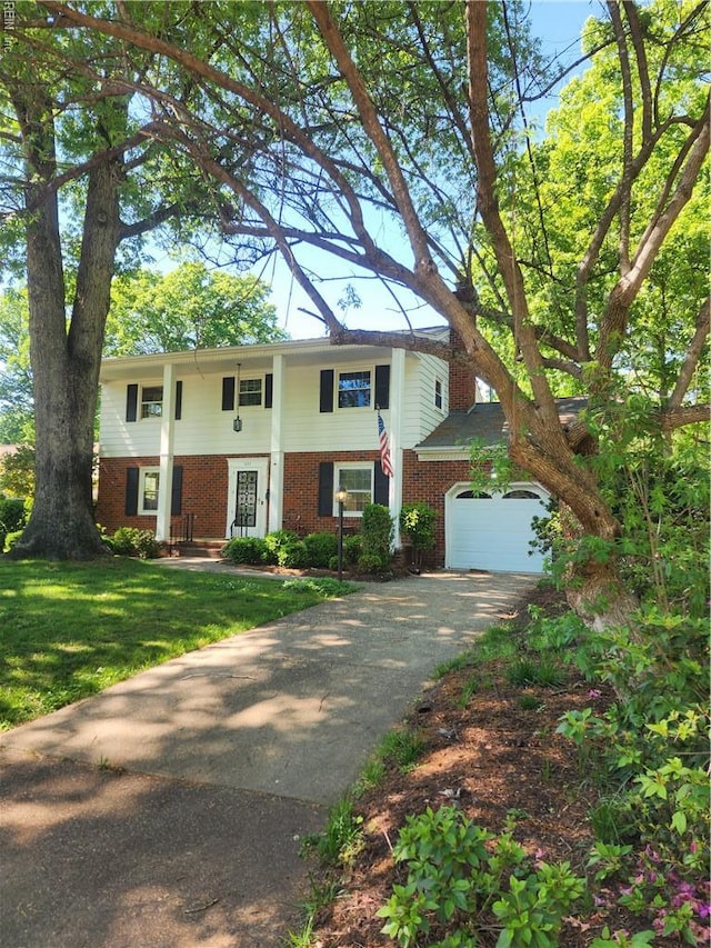 view of front of home with a front lawn, an attached garage, aphalt driveway, and brick siding