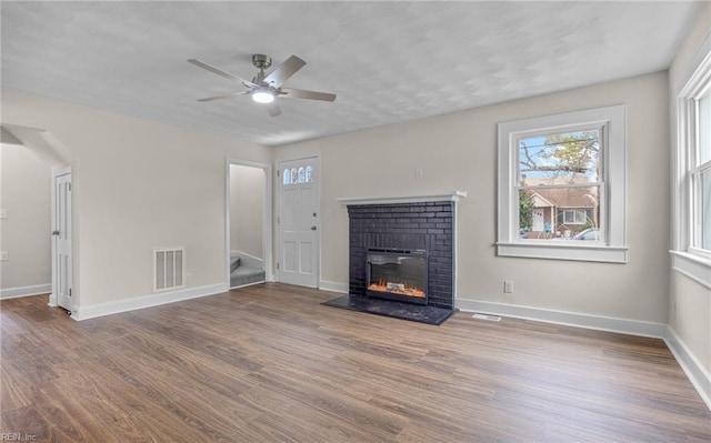 9254 Marlow Ave, Norfolk, VA 23503 - unfurnished living room featuring a ceiling fan, a brick fireplace, wood finished floors, baseboards, and stairs