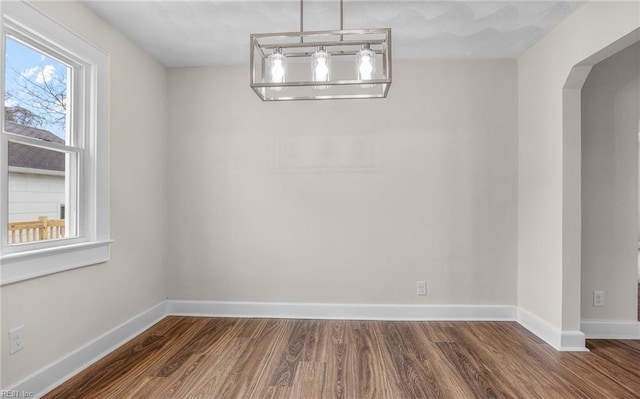 9254 Marlow Ave, Norfolk, VA 23503 - unfurnished dining area with arched walkways, baseboards, and wood finished floors