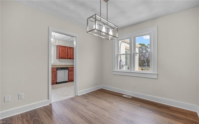 9254 Marlow Ave, Norfolk, VA 23503 - unfurnished dining area with a notable chandelier, baseboards, visible vents, and light wood-style flooring