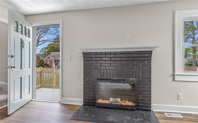 9254 Marlow Ave, Norfolk, VA 23503 - doorway to outside featuring visible vents, baseboards, a brick fireplace, and wood finished floors