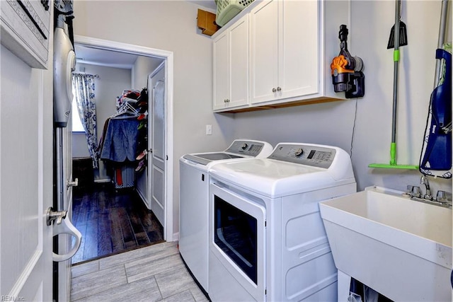 laundry room featuring a sink, cabinet space, and independent washer and dryer