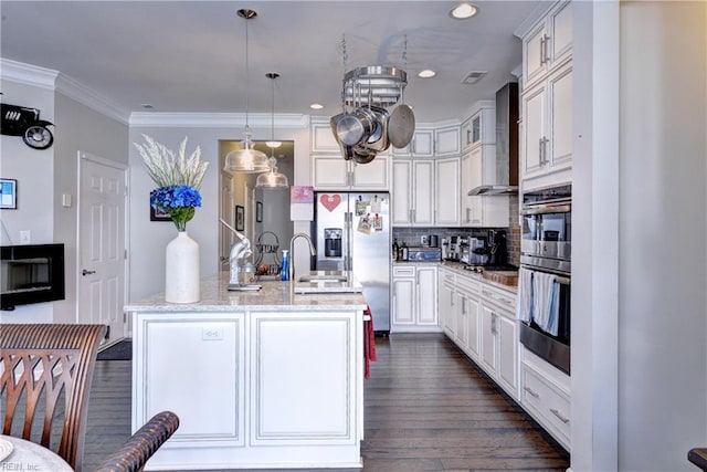 kitchen with stainless steel fridge with ice dispenser, a kitchen island with sink, wall chimney exhaust hood, decorative backsplash, and dark wood-style floors