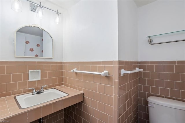 110 Greenwell Dr, Hampton, VA 23666 - bathroom featuring toilet, tile walls, a sink, and a wainscoted wall