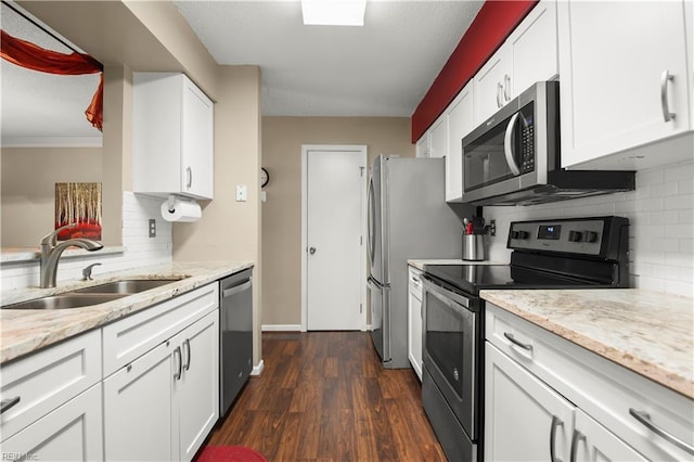 kitchen featuring dark wood-style flooring, white cabinets, tasteful backsplash, a sink, and stainless steel appliances