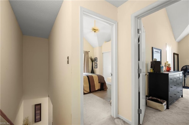 corridor featuring light carpet and lofted ceiling