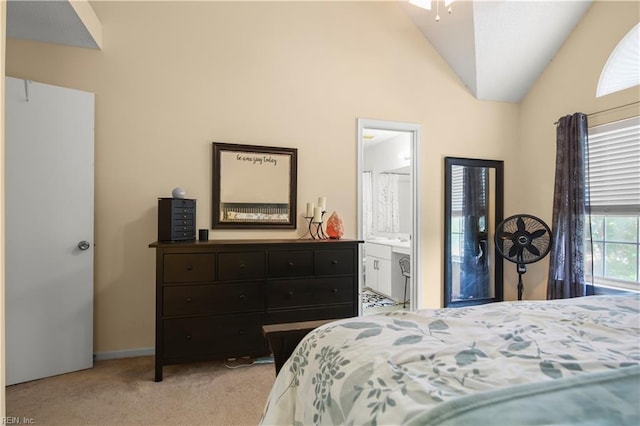 bedroom featuring carpet floors, baseboards, lofted ceiling, and ensuite bath