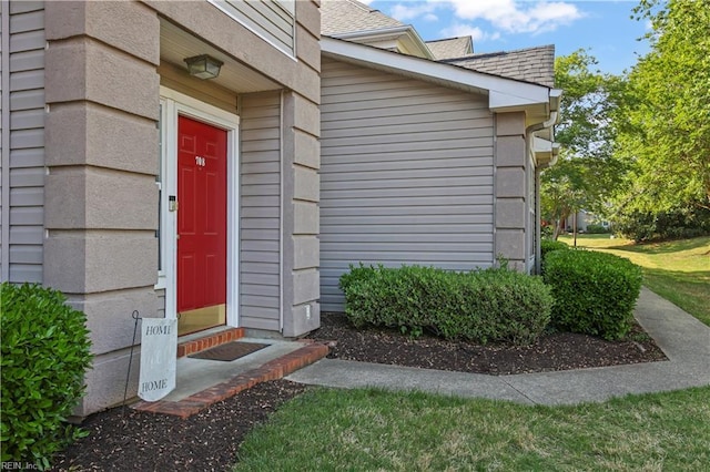 entrance to property featuring a shingled roof