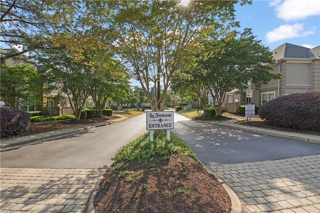 view of road with curbs, traffic signs, sidewalks, and a residential view