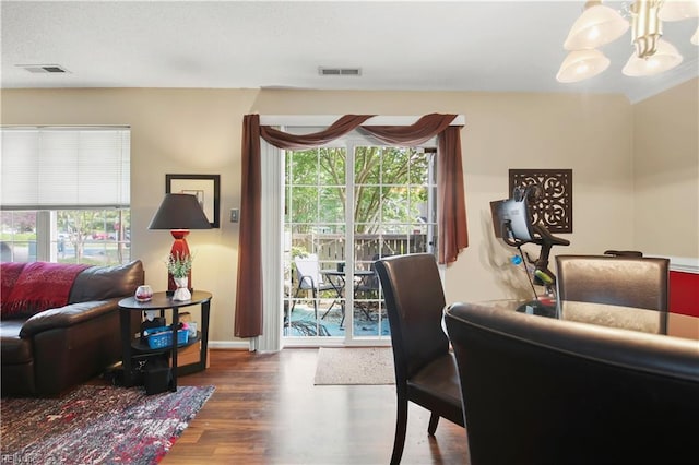 dining room with baseboards, a notable chandelier, visible vents, and wood finished floors