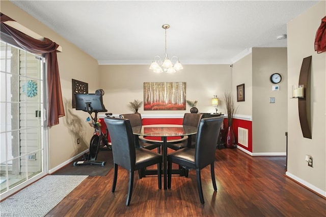 dining area featuring visible vents, wood finished floors, baseboards, a chandelier, and ornamental molding