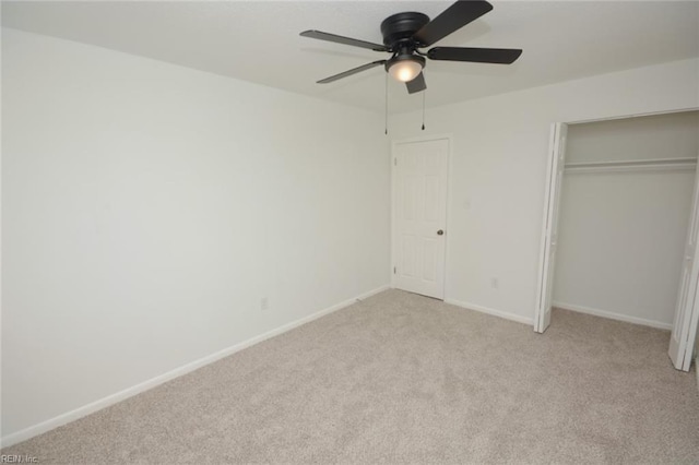 unfurnished bedroom with baseboards, a ceiling fan, a closet, and light colored carpet