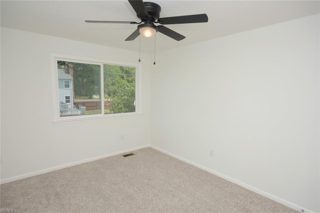 unfurnished room with carpet floors, baseboards, ceiling fan, and visible vents