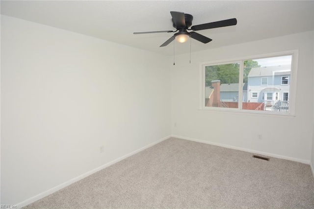 unfurnished room with visible vents, a ceiling fan, carpet, and baseboards