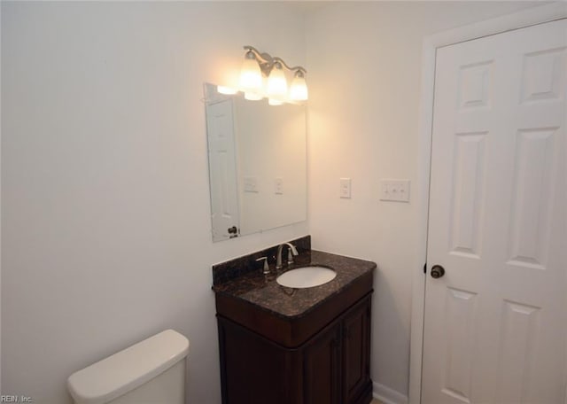 half bathroom featuring toilet and vanity