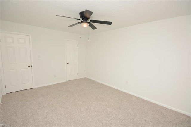 empty room featuring baseboards, light carpet, and a ceiling fan