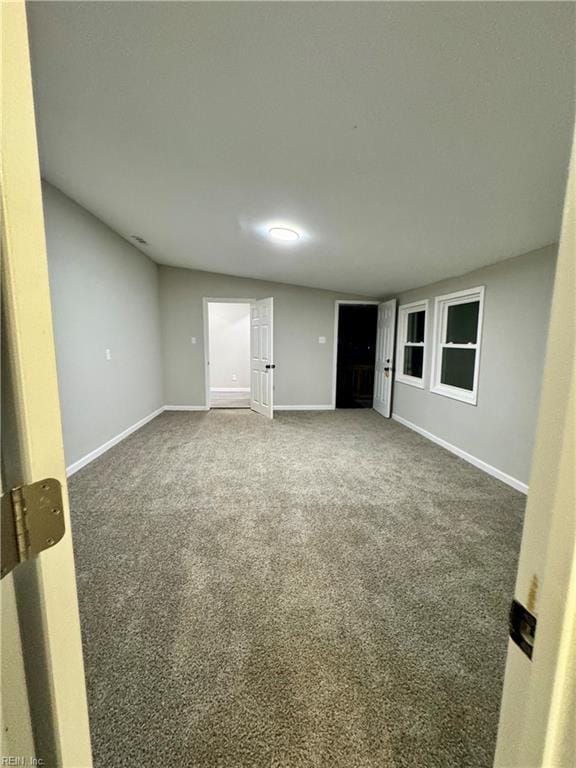 unfurnished room featuring baseboards and carpet