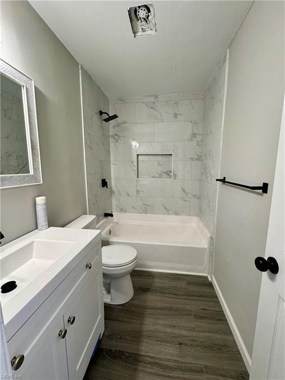 bathroom with toilet, wood finished floors, bathtub / shower combination, and vanity