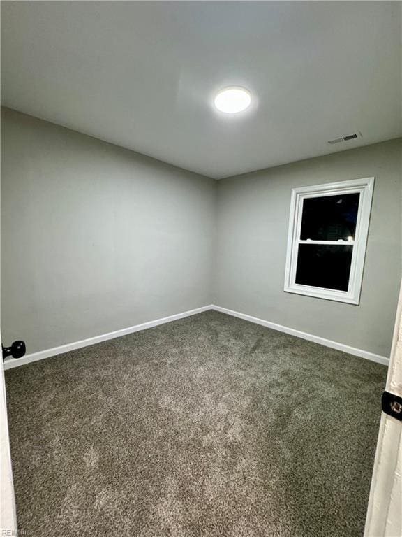 carpeted empty room with visible vents and baseboards