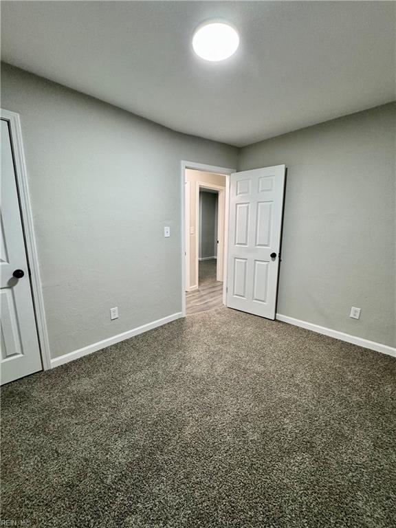 unfurnished bedroom with baseboards and carpet