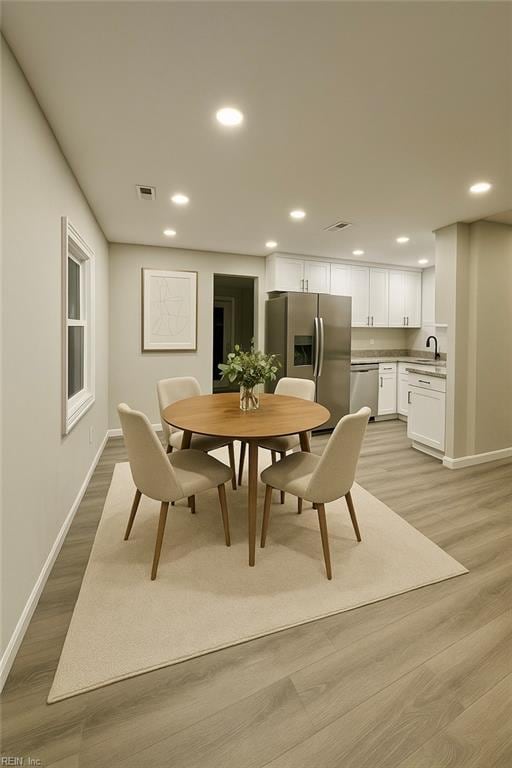 dining room with recessed lighting, visible vents, light wood-style flooring, and baseboards