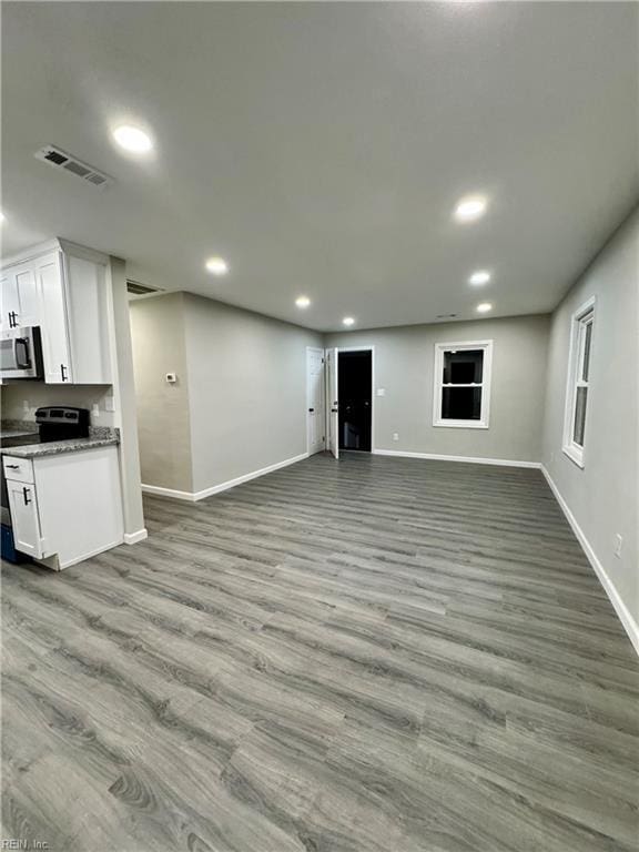interior space with wood finished floors, visible vents, recessed lighting, and baseboards
