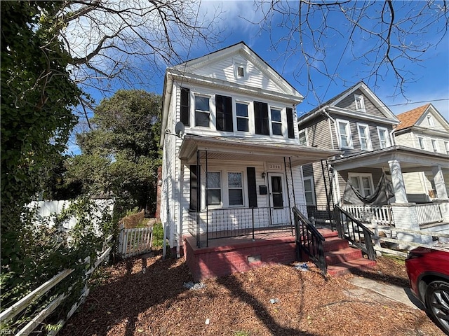 view of front of property with covered porch and fence