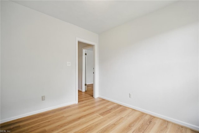 unfurnished room featuring baseboards and wood finished floors
