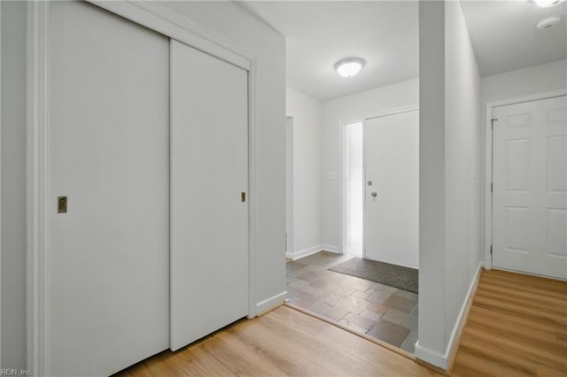 entrance foyer with baseboards and light wood-style floors