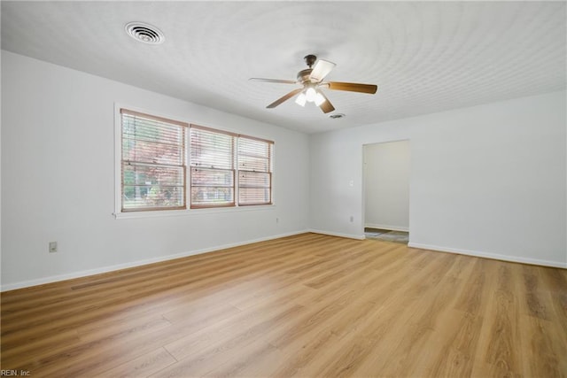 spare room with visible vents, light wood-style flooring, ceiling fan, and baseboards