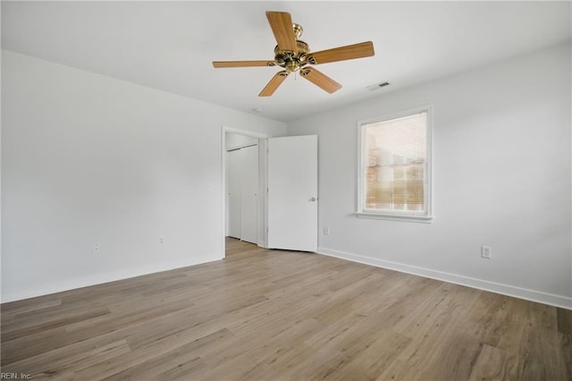 empty room with visible vents, baseboards, ceiling fan, and light wood-type flooring