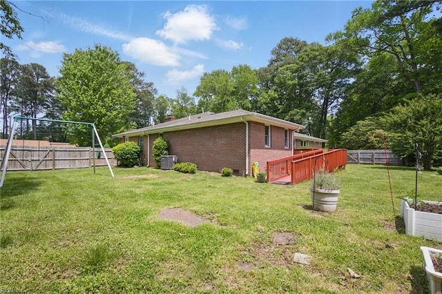 view of yard with a fenced backyard, a playground, central air condition unit, and a vegetable garden