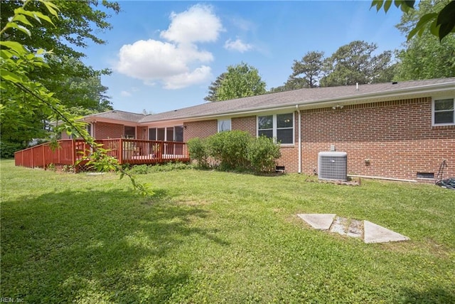 back of house featuring a yard, central AC, and brick siding