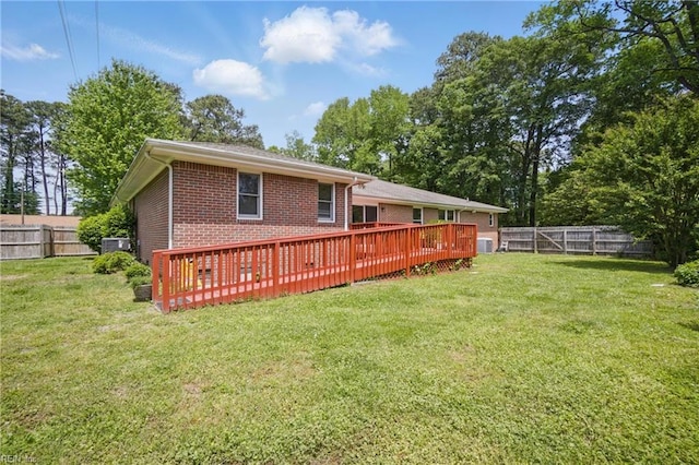 back of house featuring brick siding, a wooden deck, and a fenced backyard