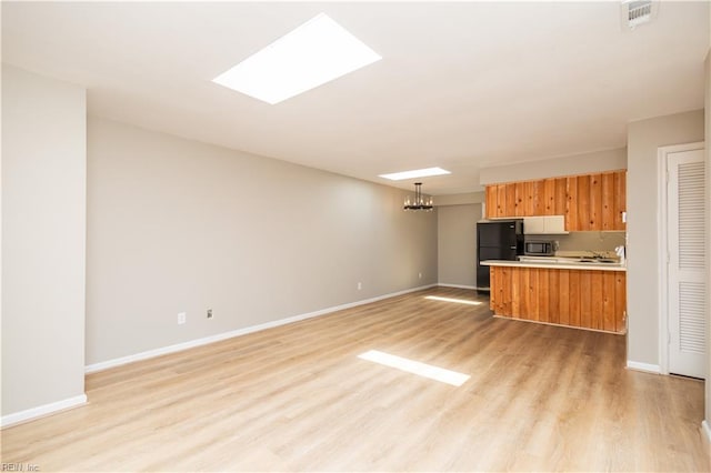 1103 Black Duck Ct, Virginia Beach, VA 23451 - kitchen with freestanding refrigerator, open floor plan, light countertops, stainless steel microwave, and light wood-style flooring