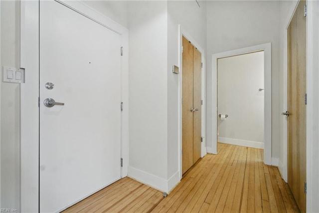 hallway with baseboards and light wood-style flooring
